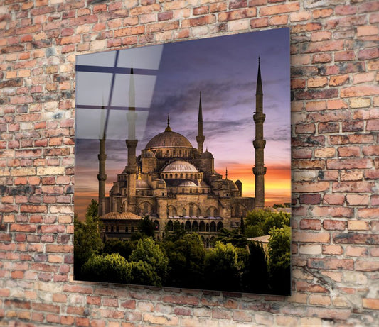 Mosque and gardens at dusk glass wall art hanging on a red brick wall