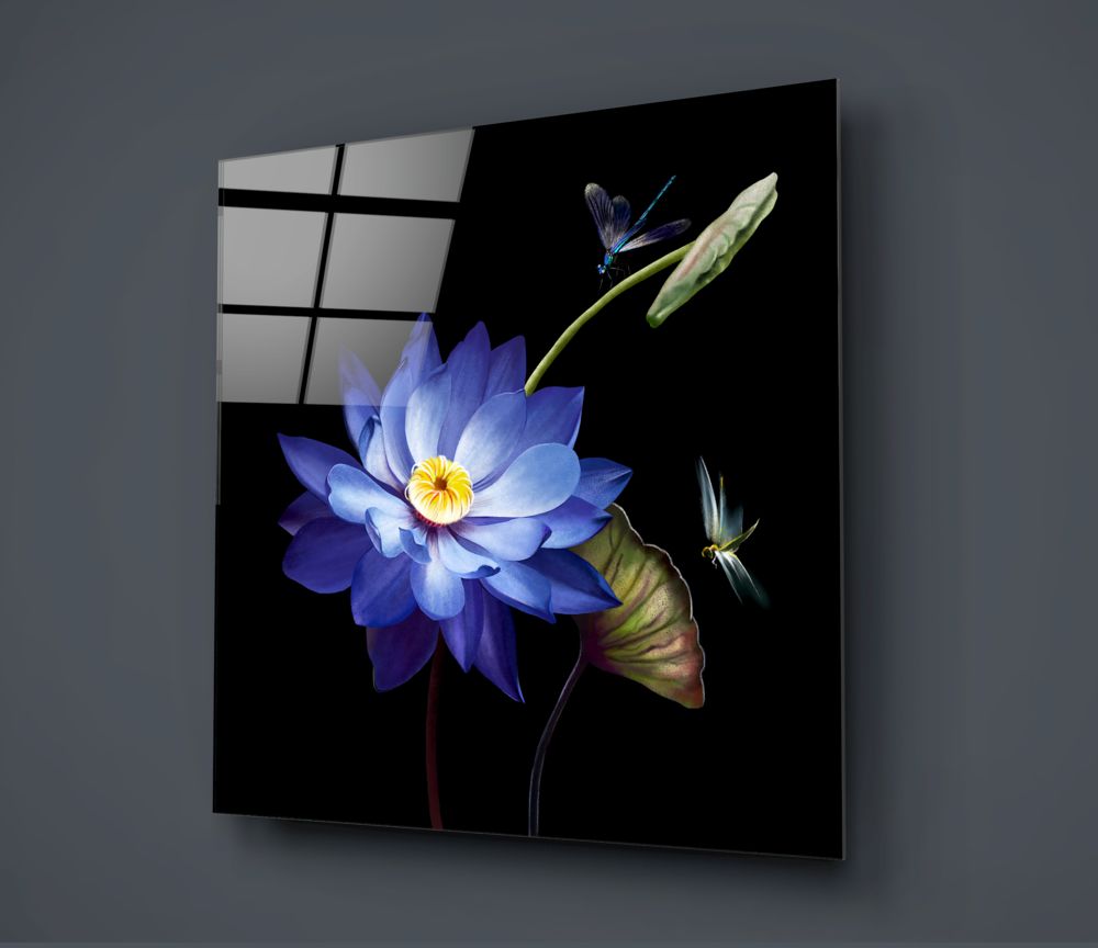 Blue lotus and dragonflies square glass wall art on a dark gray wall with a window reflection
