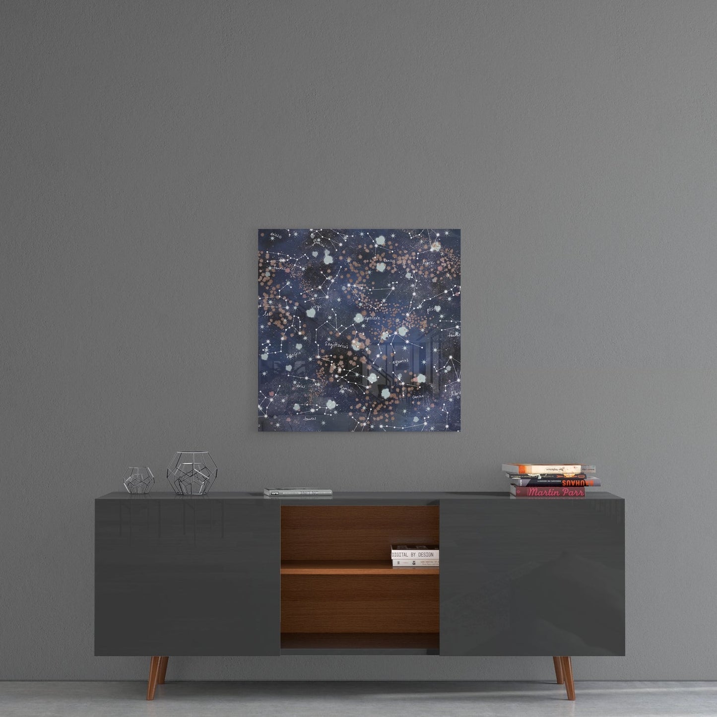 Zodiac constellations glass wall art on a gray wall above a dark sideboard with wood shelves