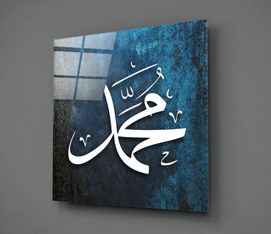 Dark teal Muhammad calligraphy glass wall art hanging on a plain gray wall, seen at an angle
