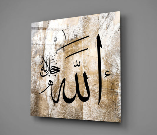 Weathered beige Allah calligraphy glass wall art hanging on a plain gray wall, seen at an angle