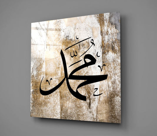 Weathered beige Muhammad calligraphy glass wall art hanging on a plain gray wall, seen at an angle