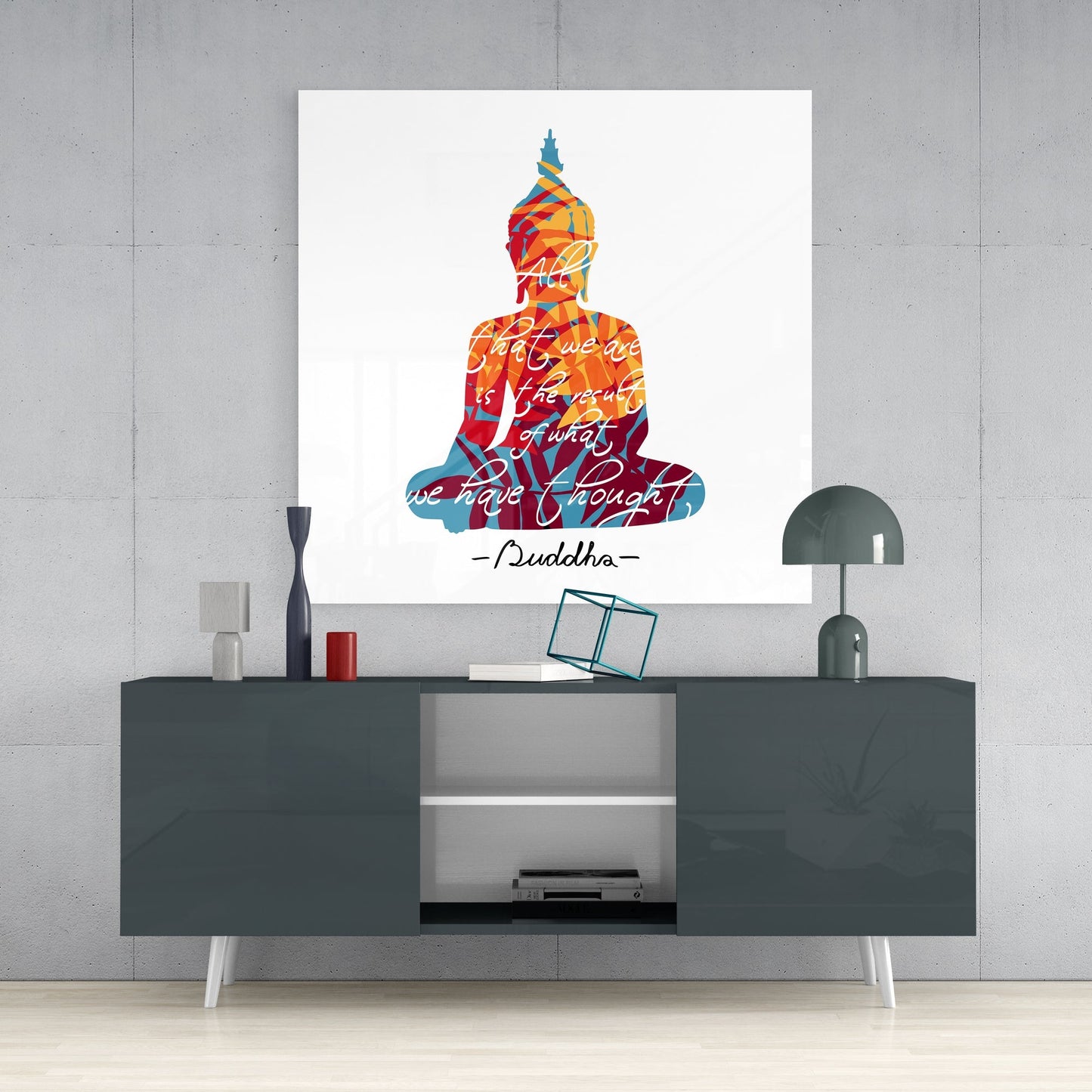 Buddha quote on white square glass wall art on a concrete wall above a dark gray sideboard