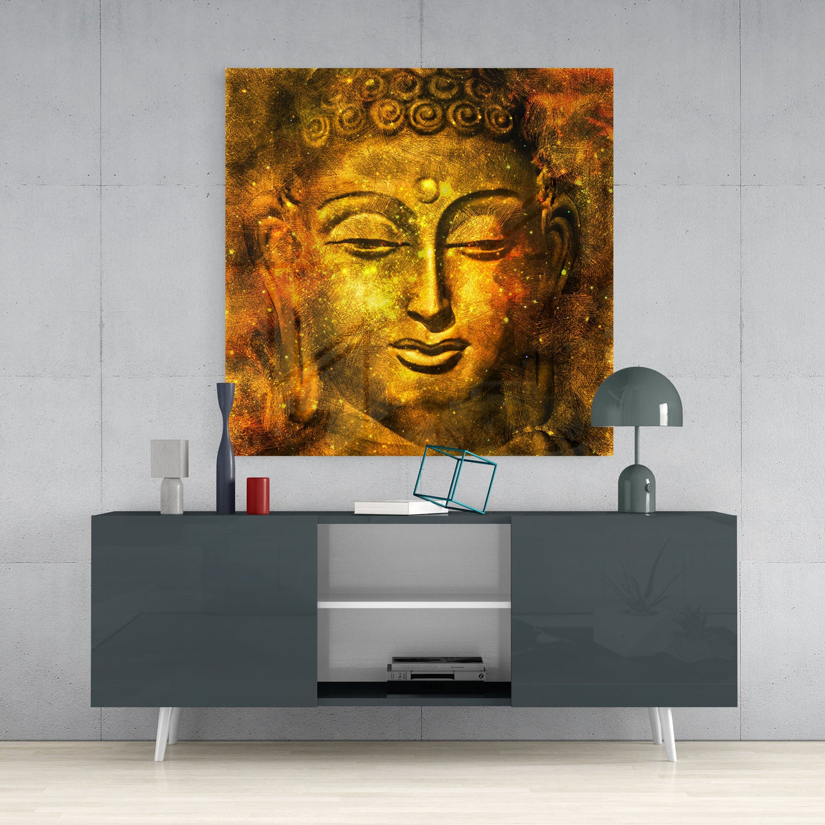 Golden Buddha face square glass wall art on a concrete wall above a dark gray sideboard