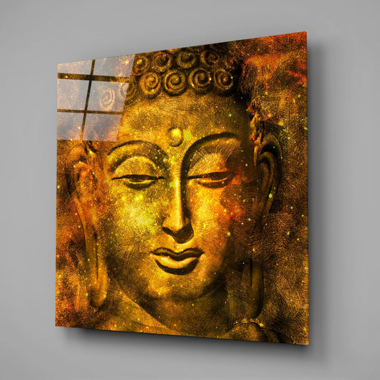 Golden Buddha face square glass wall art on a gray wall with a window reflection in the glass