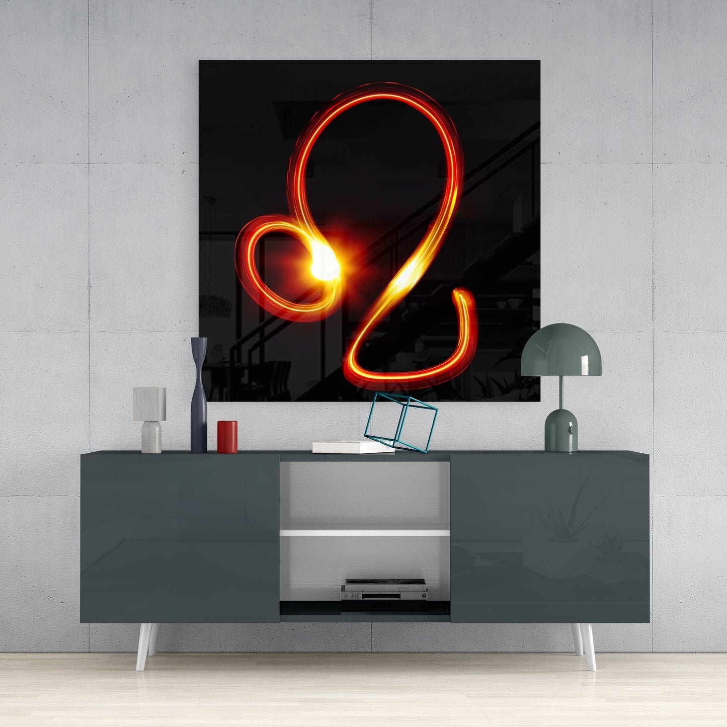 Leo light trail glass wall art above a dark gray sideboard with a dome lamp and a teal wire cube