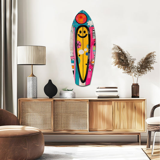 Smiley pop collage surfboard glass wall art above a rattan sideboard with a table lamp and pampas grass