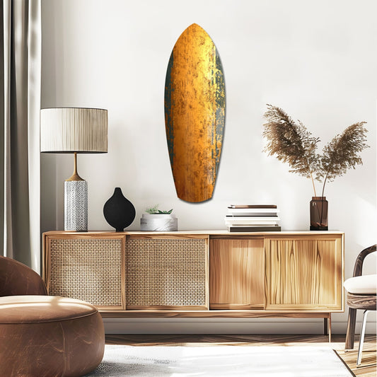 Burnished gold surfboard glass wall art above a rattan sideboard with a table lamp and pampas grass