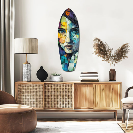 Mosaic face surfboard glass wall art above a rattan sideboard with a table lamp and pampas grass