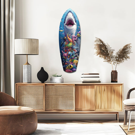 Shark and reef fish surfboard glass wall art above a rattan sideboard with a table lamp and pampas grass