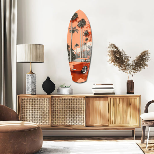 Red car and palms surfboard glass wall art above a rattan sideboard with a table lamp and pampas grass