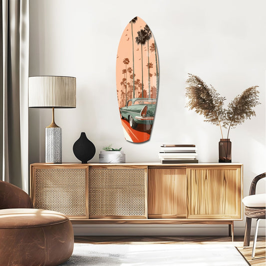 Teal car and palms surfboard glass wall art above a rattan sideboard with a table lamp and pampas grass