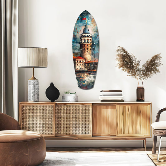 Galata Tower surfboard glass wall art above a rattan sideboard with a table lamp and pampas grass
