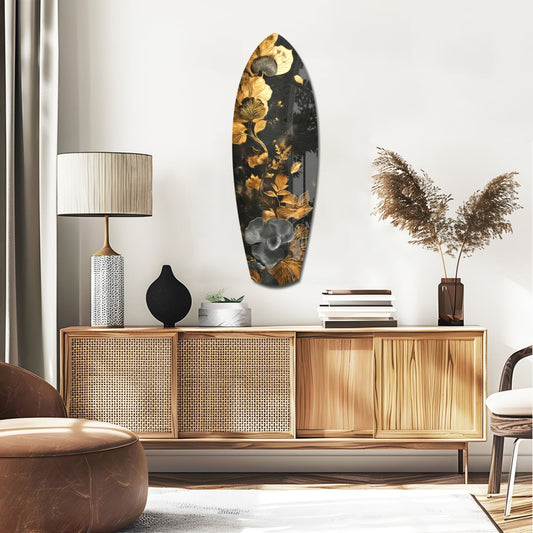 Gold Flowers on Black surfboard glass wall art above a rattan sideboard with a table lamp and pampas grass