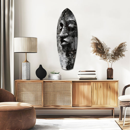 Black and White Grunge Face surfboard glass wall art above a rattan sideboard with a table lamp and pampas grass