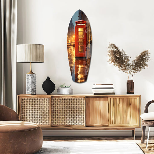 London phone booth surfboard glass wall art above a rattan sideboard with a lamp and pampas grass