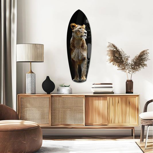 Standing lioness surfboard glass wall art above a rattan sideboard with a table lamp and pampas grass