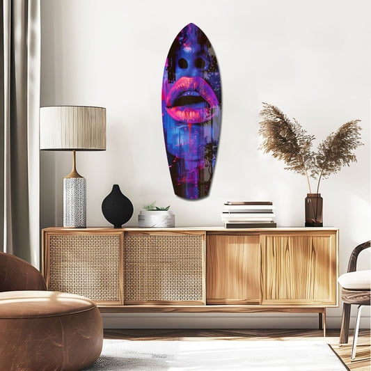 Blue and violet neon lips face surfboard glass wall art above a rattan sideboard with a table lamp and pampas grass