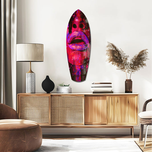 Crimson neon lips face surfboard glass wall art above a rattan sideboard with a table lamp and pampas grass