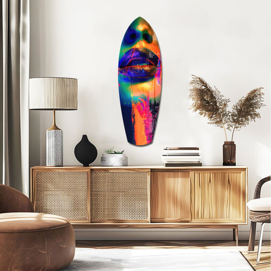 Indigo lips on orange face surfboard glass wall art above a rattan sideboard with a table lamp and pampas grass