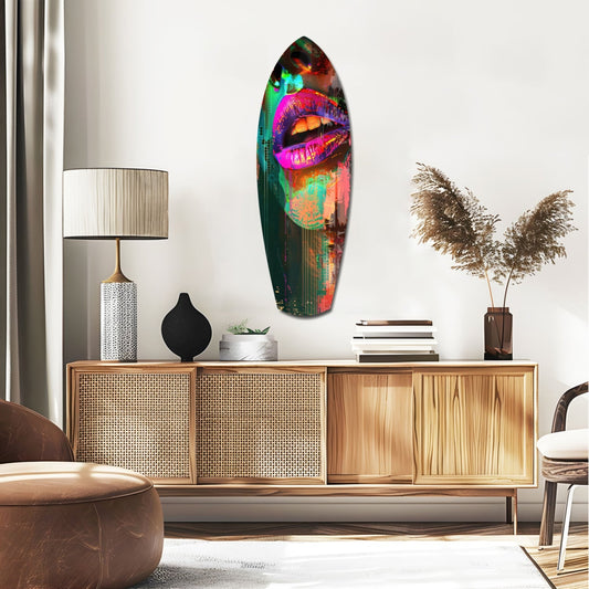 Magenta lips with green glitch surfboard glass wall art above a rattan sideboard with a table lamp and pampas grass