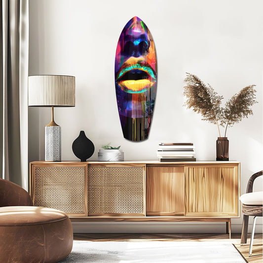 Yellow and turquoise lips surfboard glass wall art above a rattan sideboard with a table lamp and pampas grass
