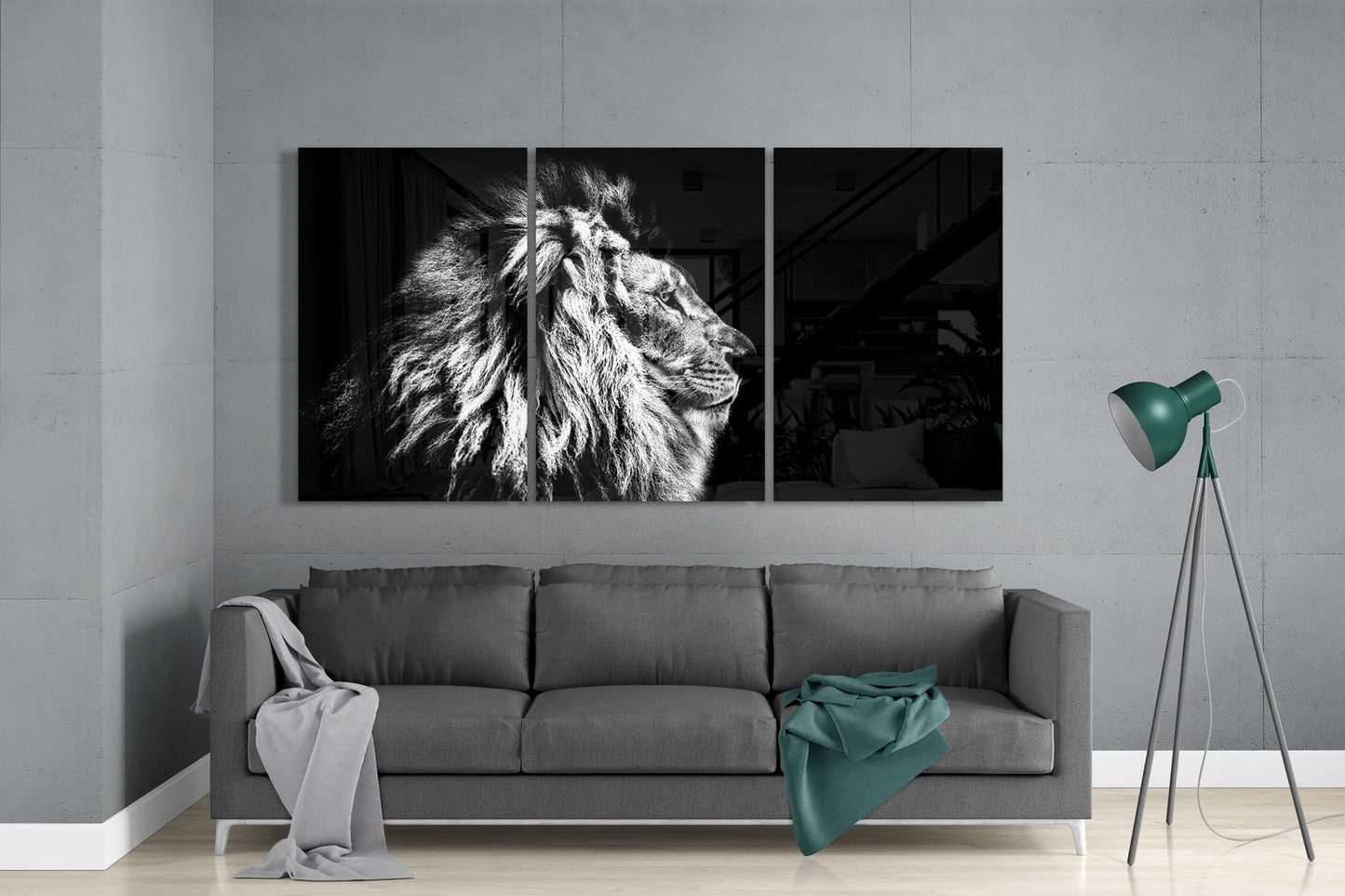 Black and white lion profile 3-panel glass wall art set above a gray sofa with red and tan throws beside a tripod lamp