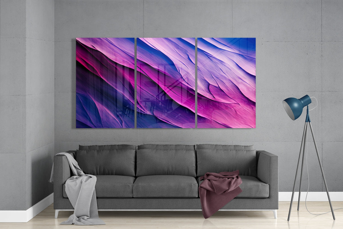 Purple and blue waves 3-panel glass wall art set above a gray sofa beside a tripod floor lamp