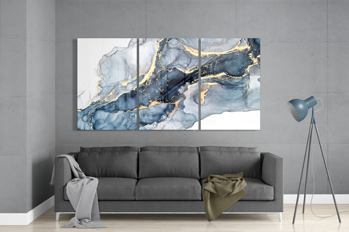 Blue and gold marble ink glass wall art set above a gray sofa beside a tripod floor lamp