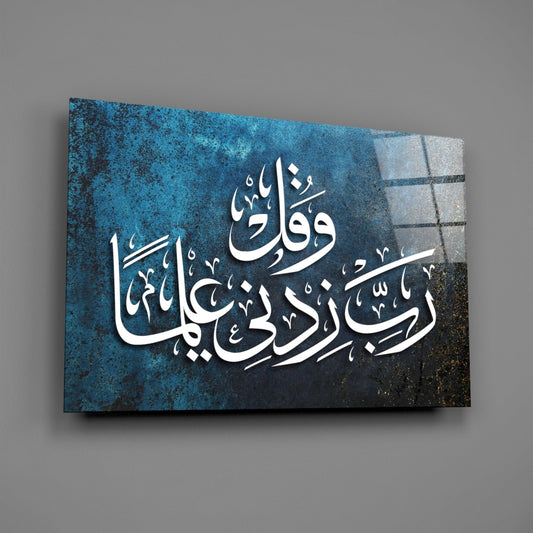 Teal Rabbi Zidni Ilma calligraphy glass wall art hanging on a plain gray wall, seen at an angle