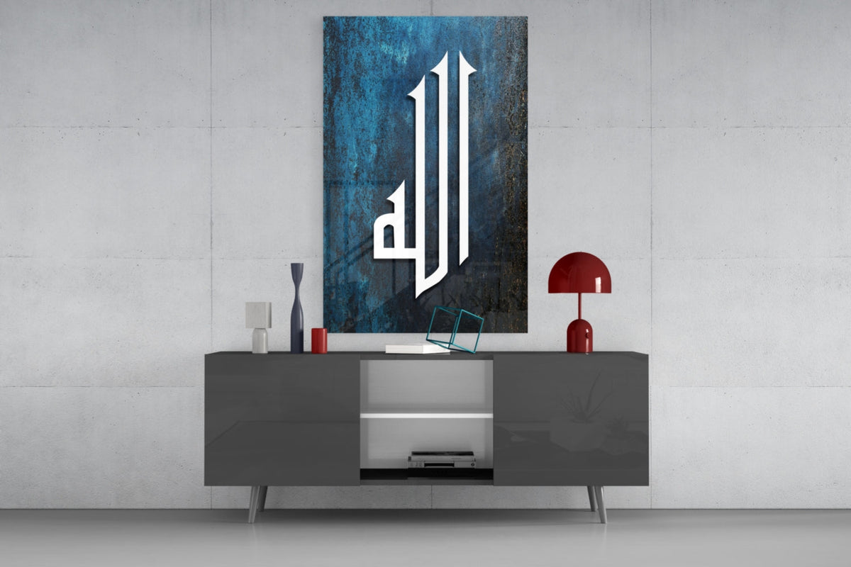 Teal Kufic Allah calligraphy glass wall art above a gray sideboard with a red table lamp