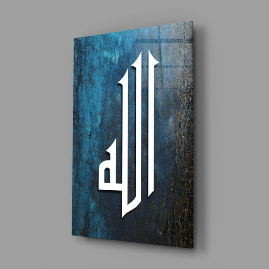 Teal Kufic Allah calligraphy glass wall art hanging on a plain gray wall, seen at an angle