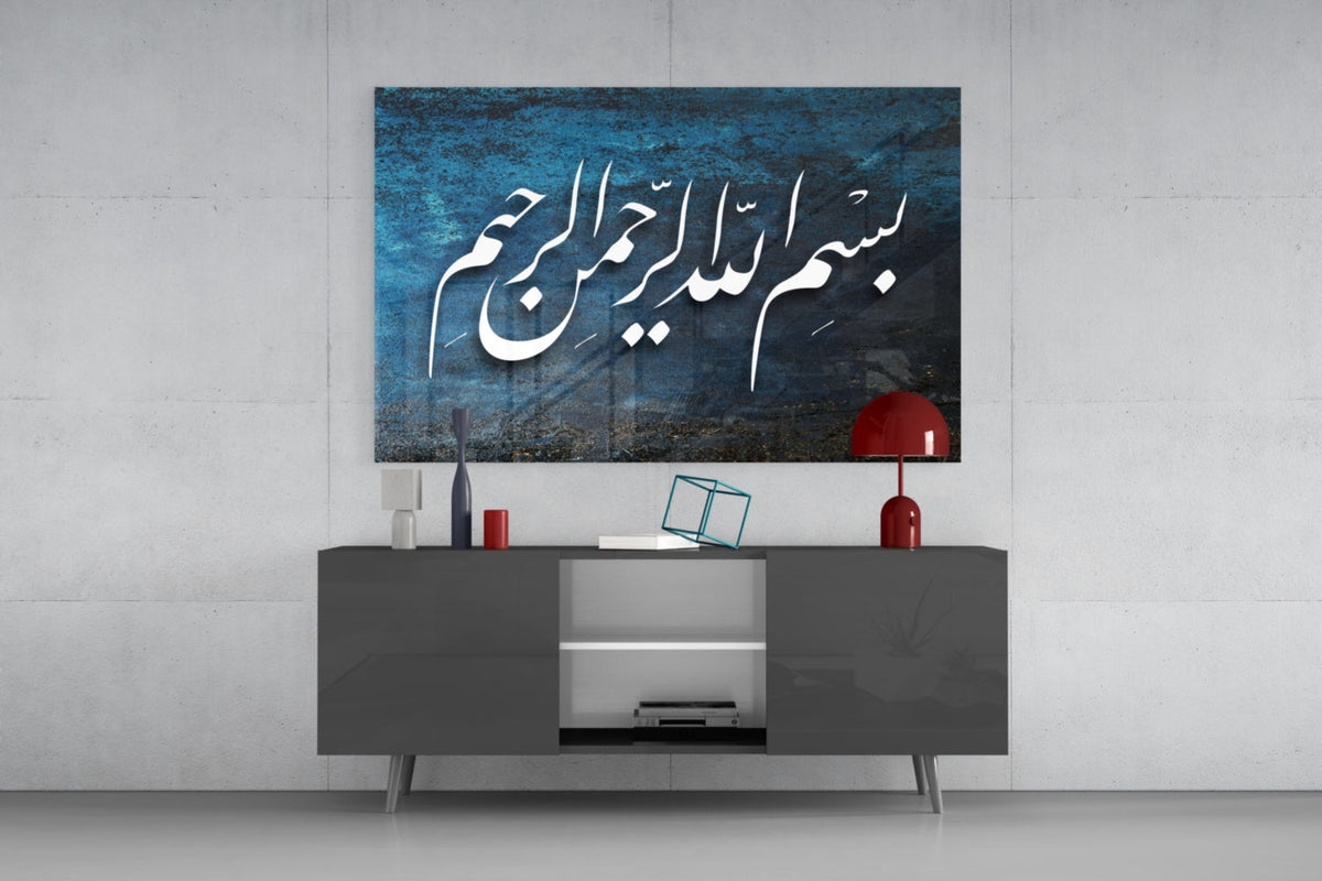 Teal Bismillah naskh calligraphy glass wall art above a gray sideboard with a red table lamp