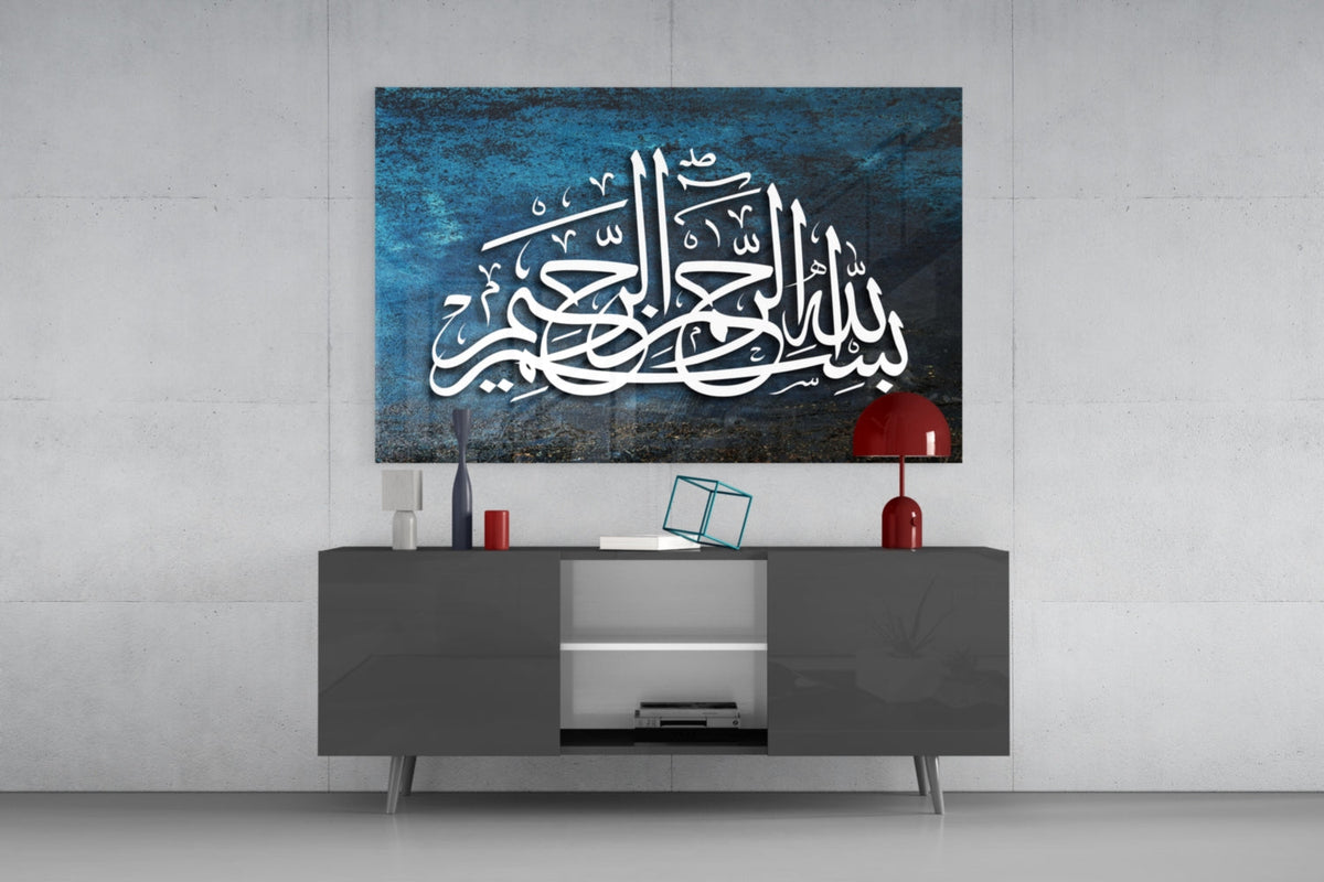 Teal Bismillah thuluth calligraphy glass wall art above a gray sideboard with a red table lamp