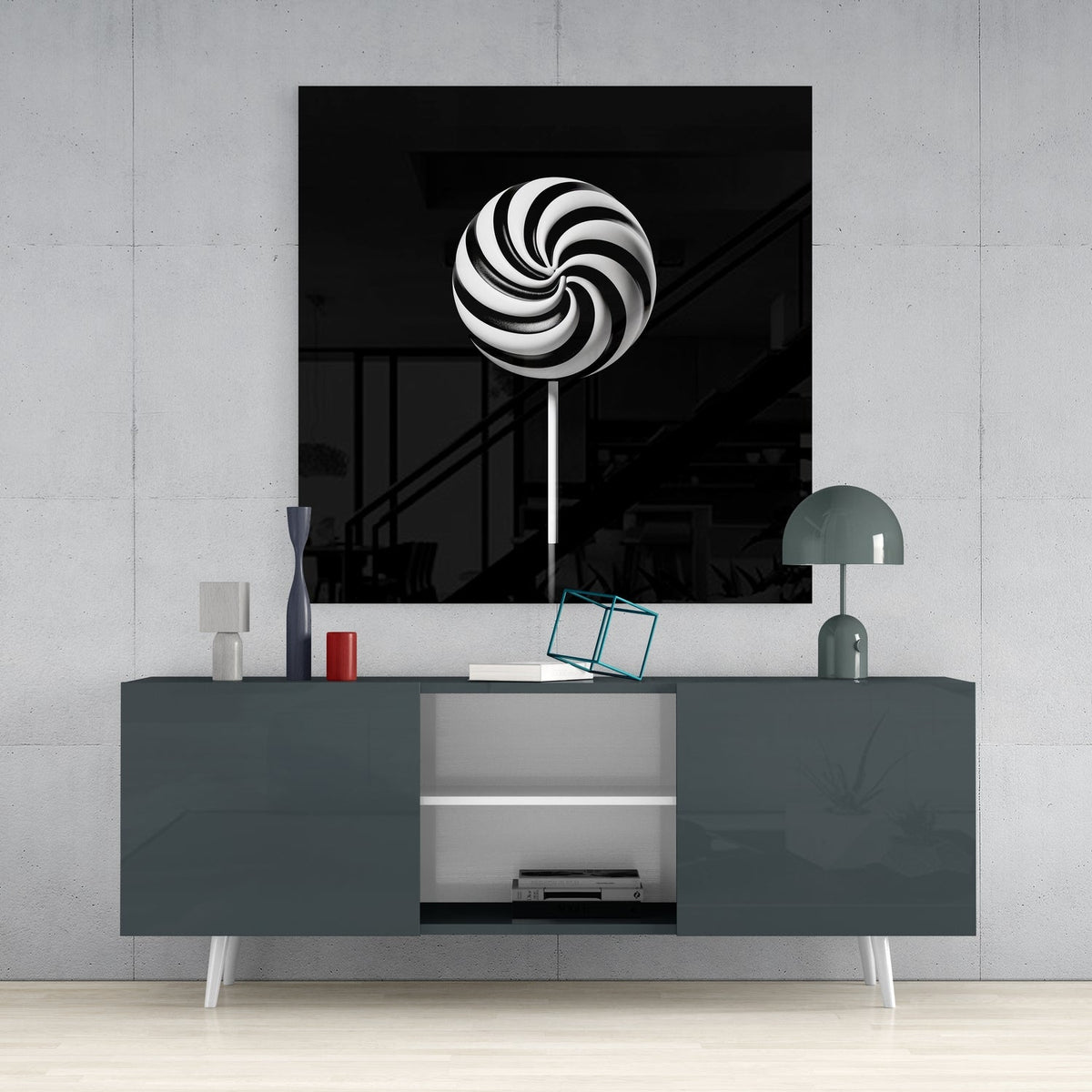 Swirl lollipop glass wall art on a light gray wall above a dark gray sideboard with a lamp