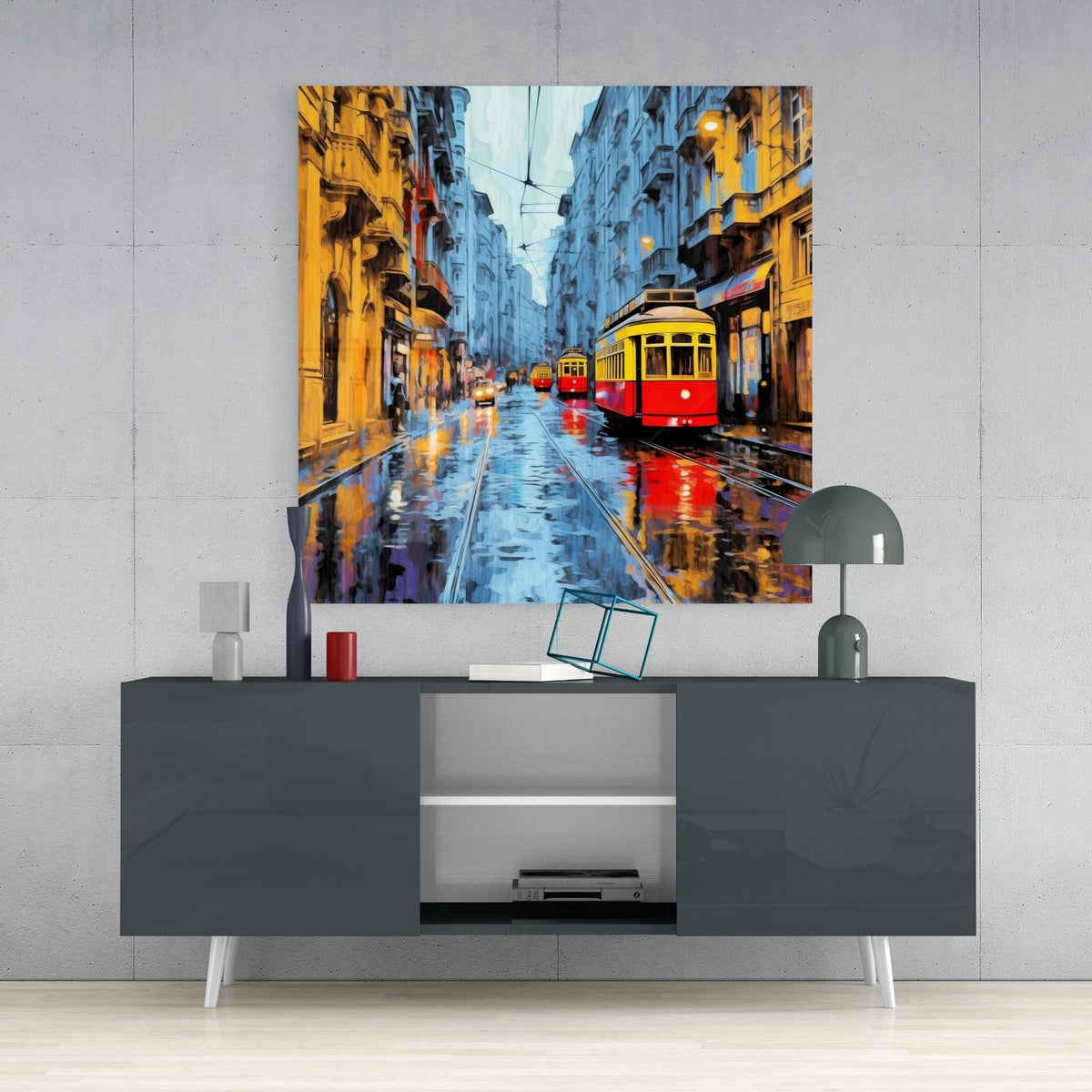 Blue dusk tram on a rainy street glass wall art above a gray sideboard with a small lamp