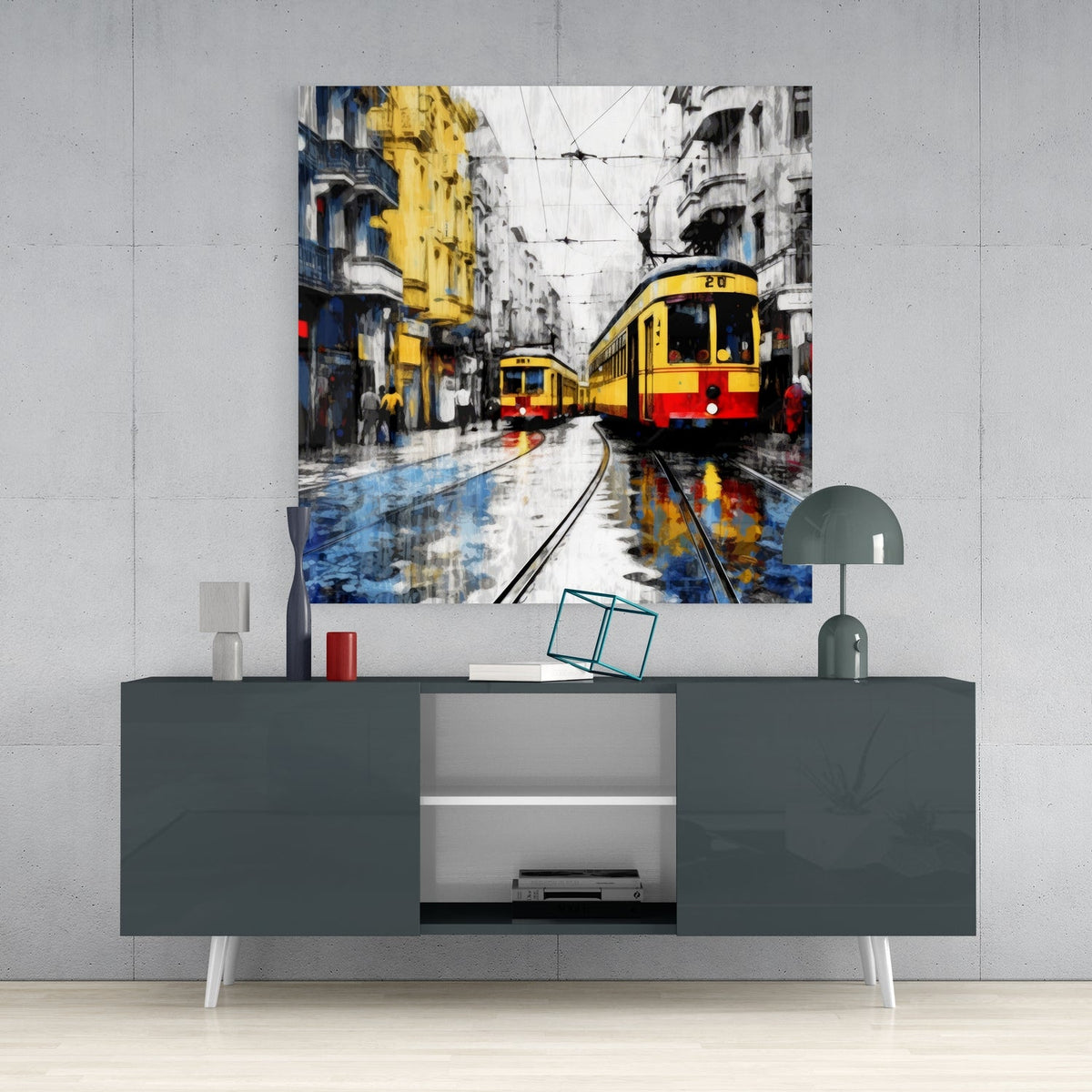 Two yellow trams on wet tracks glass wall art above a gray sideboard with a small lamp