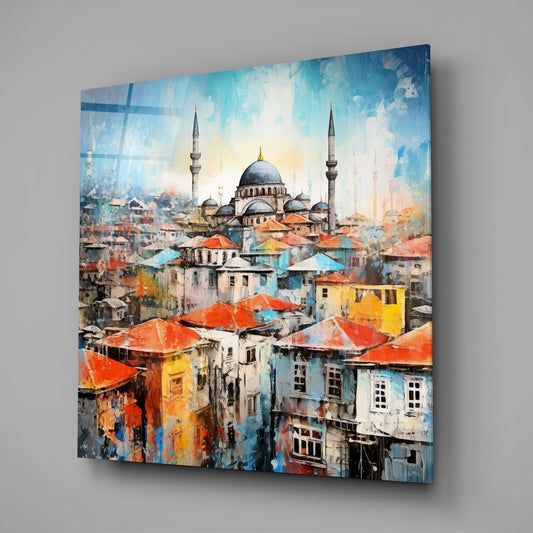 Hillside town and mosque glass wall art hanging on a plain gray wall, seen at an angle