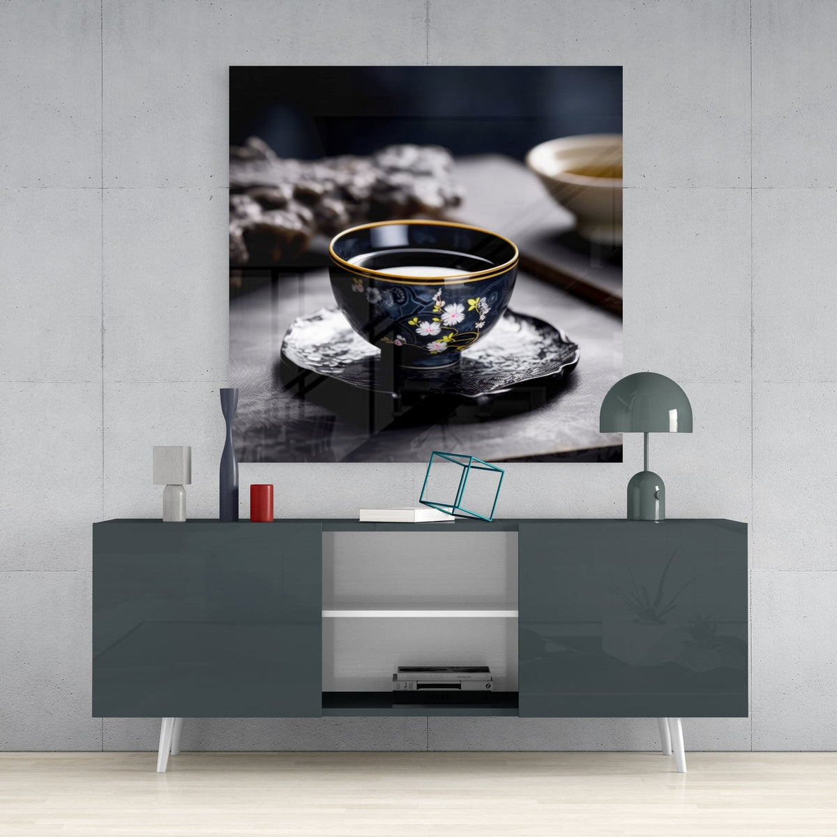 Porcelain tea cup still life glass wall art above a gray console with a small lamp