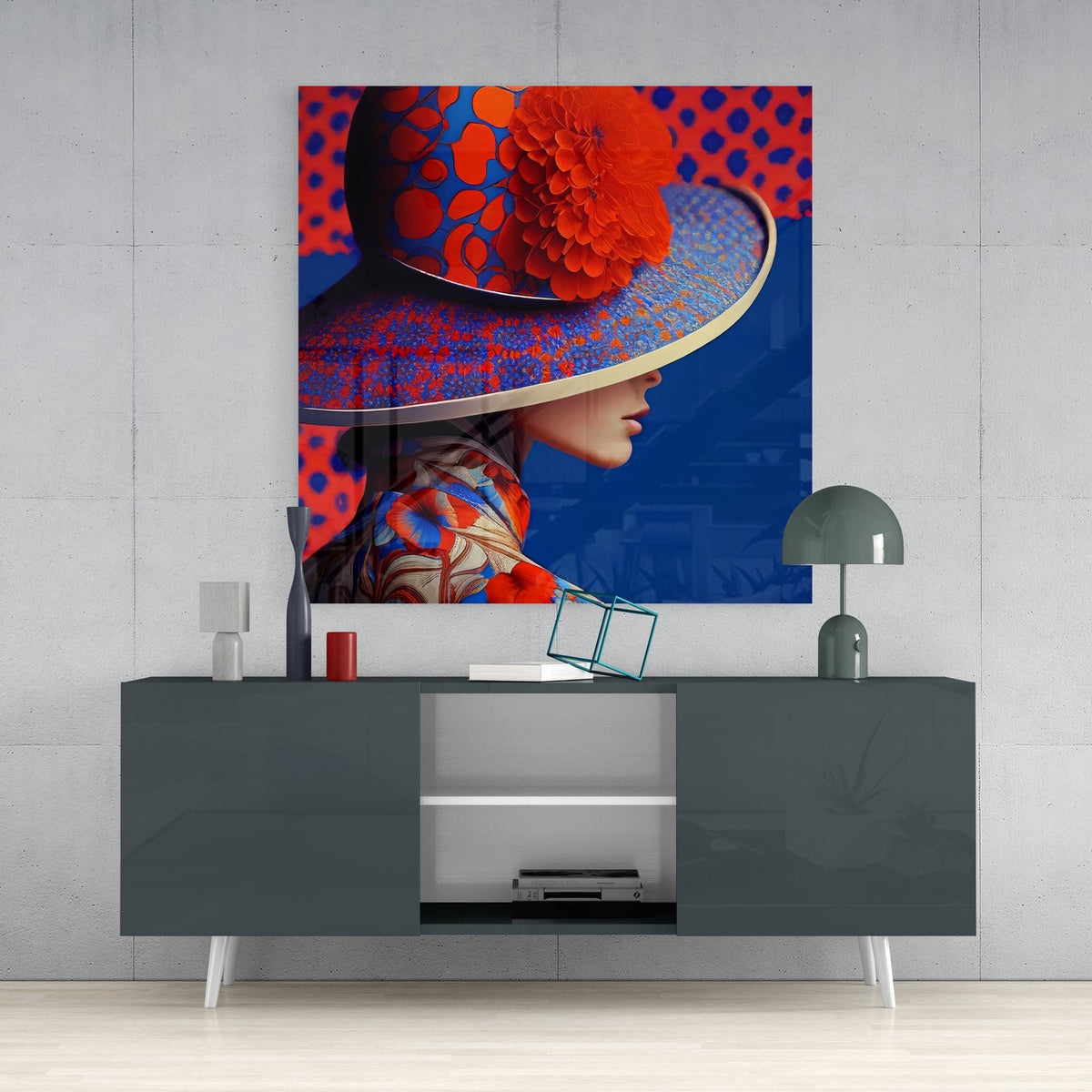 Woman in red hat square glass wall art on a concrete wall above a dark gray sideboard