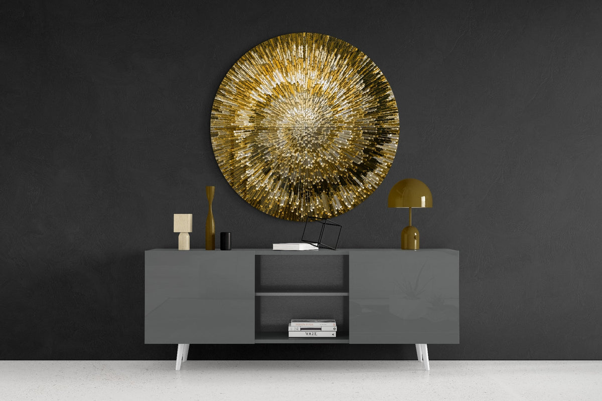 Golden helix burst round glass wall art on a dark wall above a gray sideboard with vases