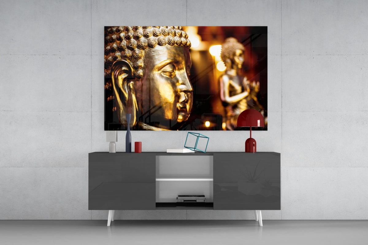 Golden Buddha and candlelight glass wall art above a gray sideboard with a red table lamp and a teal wire cube