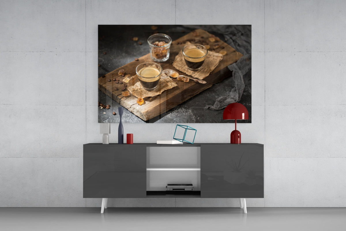 Two espresso shots on wood board glass wall art above a gray sideboard with a red table lamp