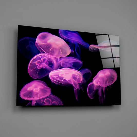 Pink glowing jellyfish on black glass wall art hung on a plain gray wall