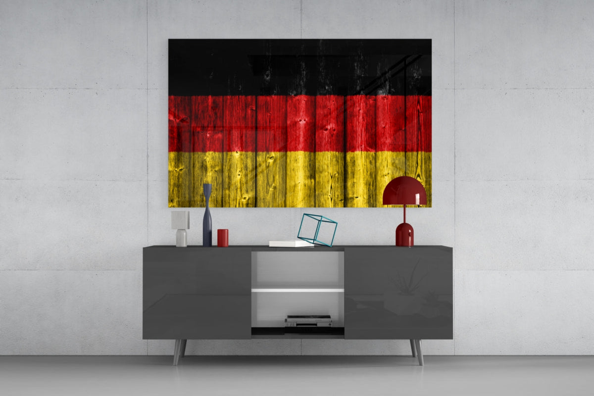 Germany wood plank flag glass wall art above a dark gray sideboard against a pale concrete wall