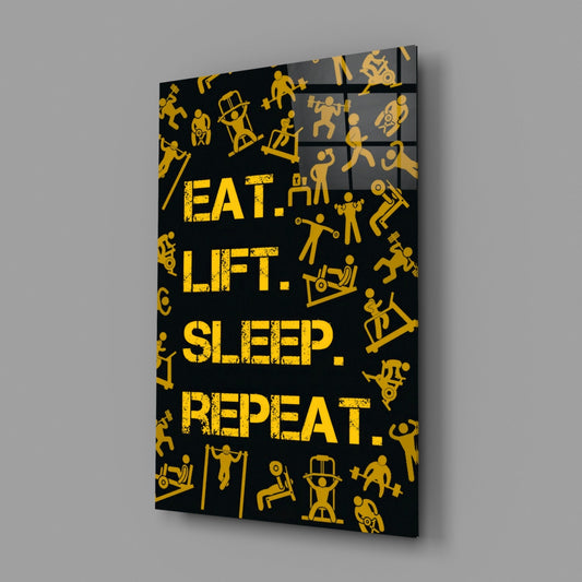 Gold eat lift sleep repeat glass wall art on a gray wall with a window reflection in the glossy front