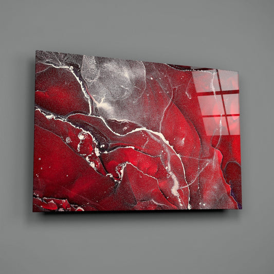 Red marble abstract glass wall art on a gray wall, light reflecting off the glossy front
