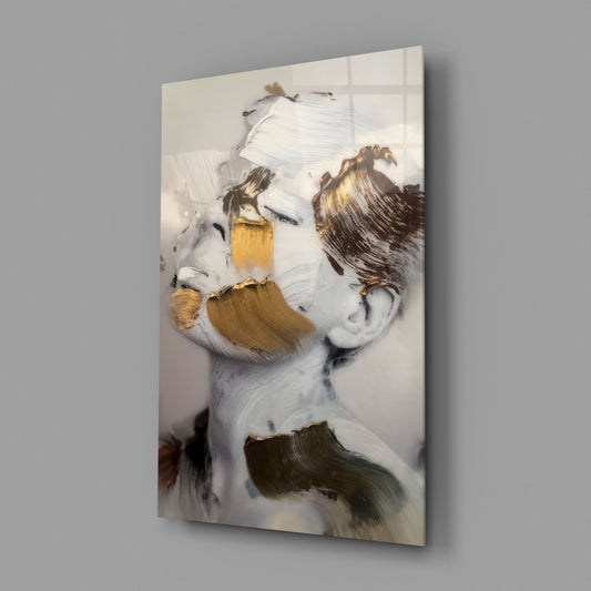 Gold and ivory brushstroke face glass wall art on a gray wall with a window reflection across the glossy glass