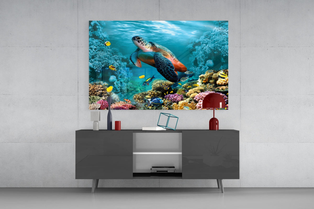 Sea turtle over coral reef glass wall art above a gray sideboard with a red table lamp