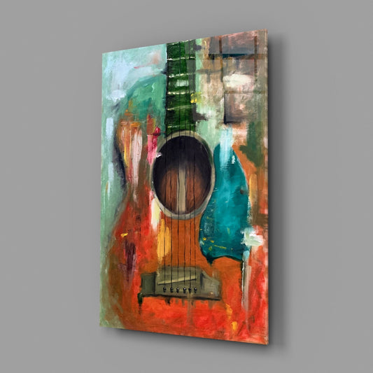 Painted acoustic guitar glass wall art on a gray wall with a soft window reflection